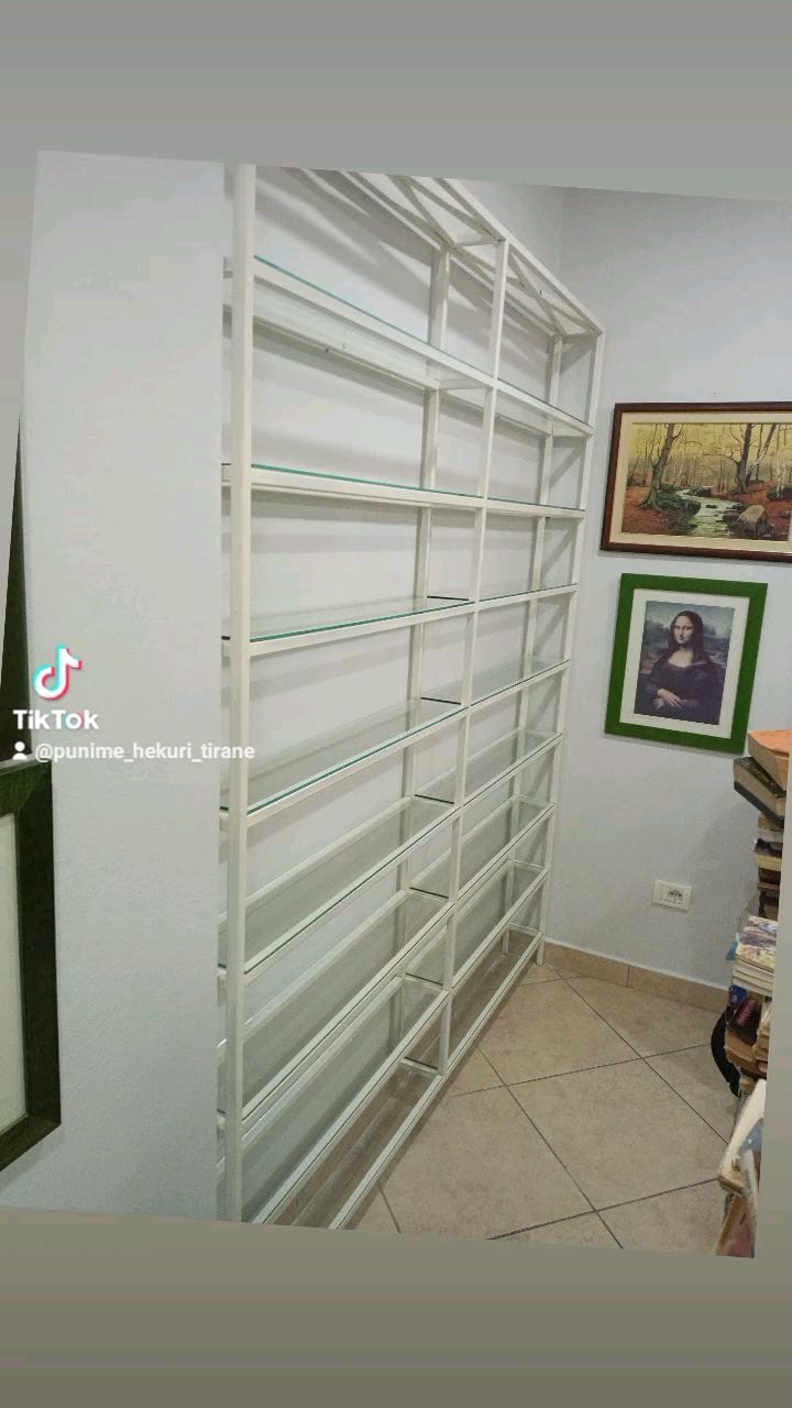 Bibliotekë metalike e bardhë me rafte xhami, pas montimit